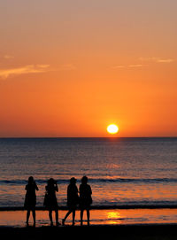 Silhouette people on beach during sunset