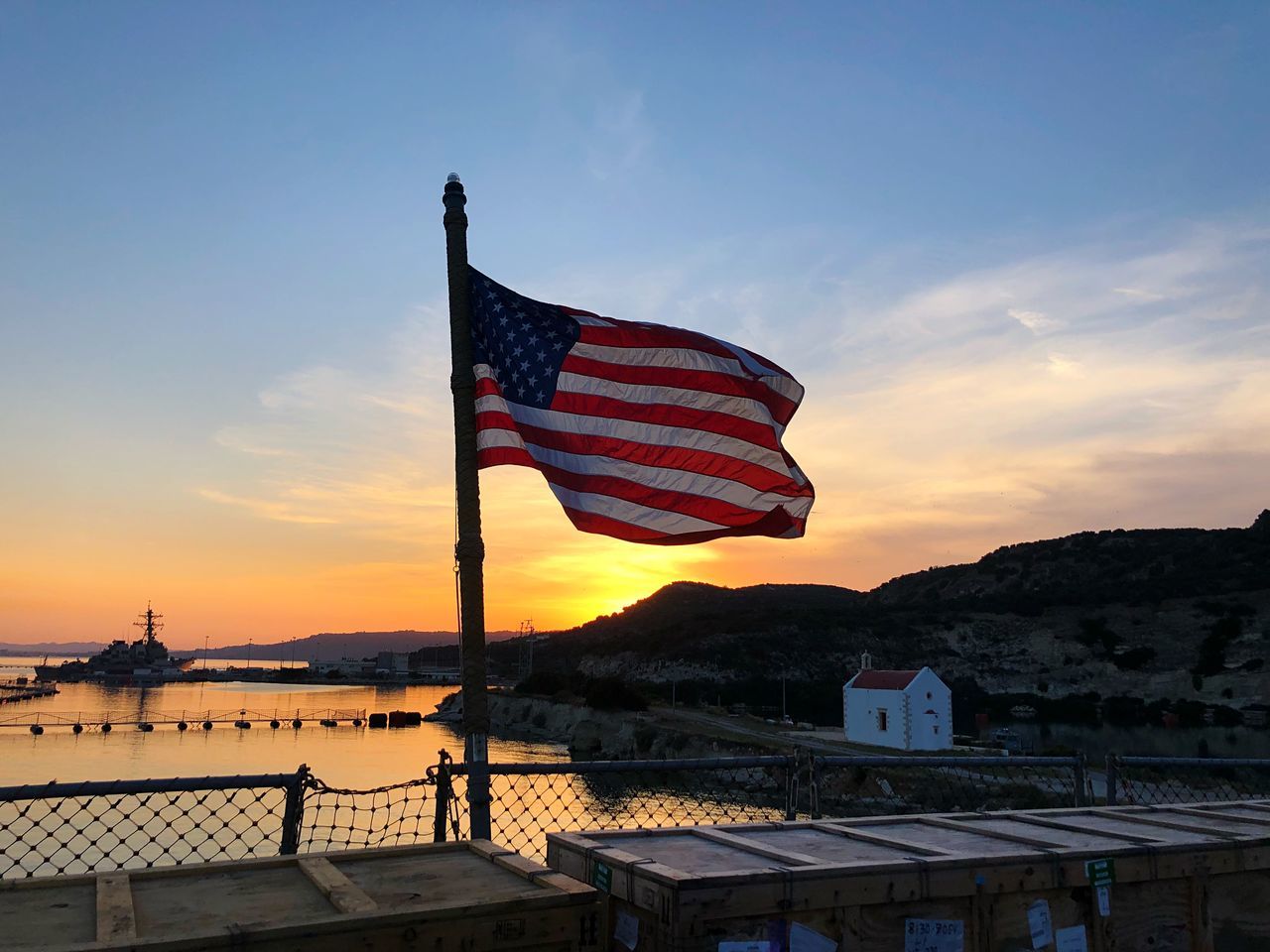 sky, sunset, flag, patriotism, nature, architecture, water, mountain, built structure, no people, cloud - sky, building exterior, beauty in nature, outdoors, orange color, pole, wind, independence