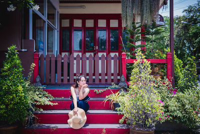 Woman sitting in yard against building