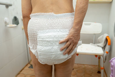 Midsection of woman standing in bathroom