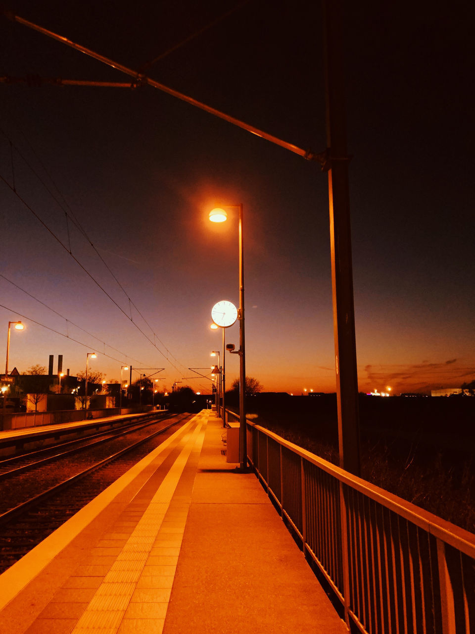 ILLUMINATED RAILROAD STATION AGAINST SKY AT NIGHT