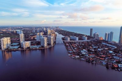 High angle view of buildings by sea against sky