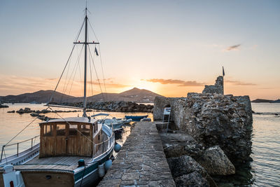 Sailboats moored on sea against buildings