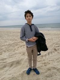 Full length portrait of boy standing at beach