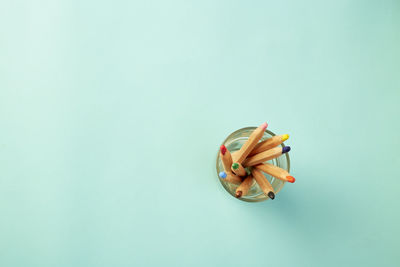 High angle view of multi colored pencils against blue background