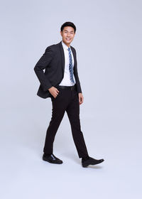 Portrait of young man standing against white background