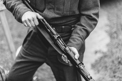 Midsection of man with gun