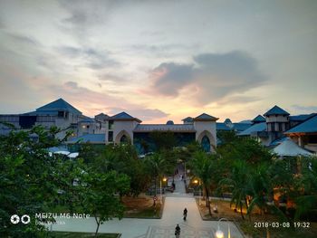 People in city against sky at sunset