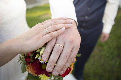 Midsection of bride holding bouquet