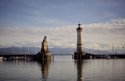 Lighthouse by sea against sky in city