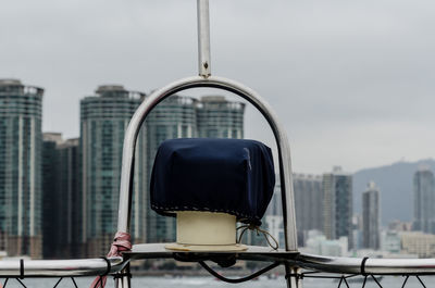 Close-up of coin-operated binoculars against cityscape