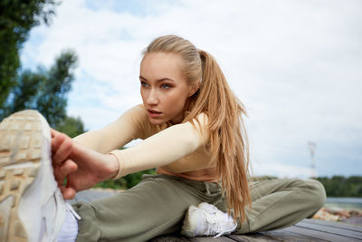 Portrait of smiling young woman sitting on field