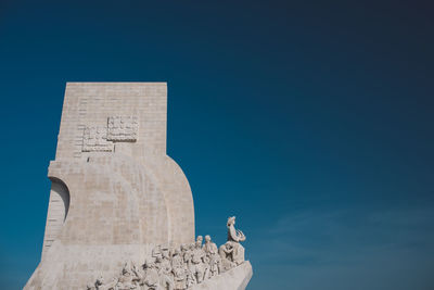 Low angle view of statue against blue sky