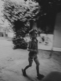 Side view of boy running on street in city