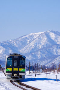 Train on snowcapped mountains against clear sky