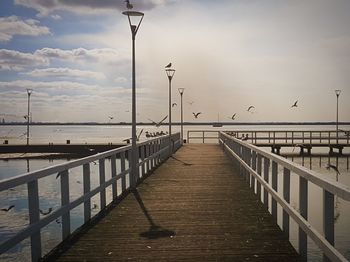 Pier on beach against sky