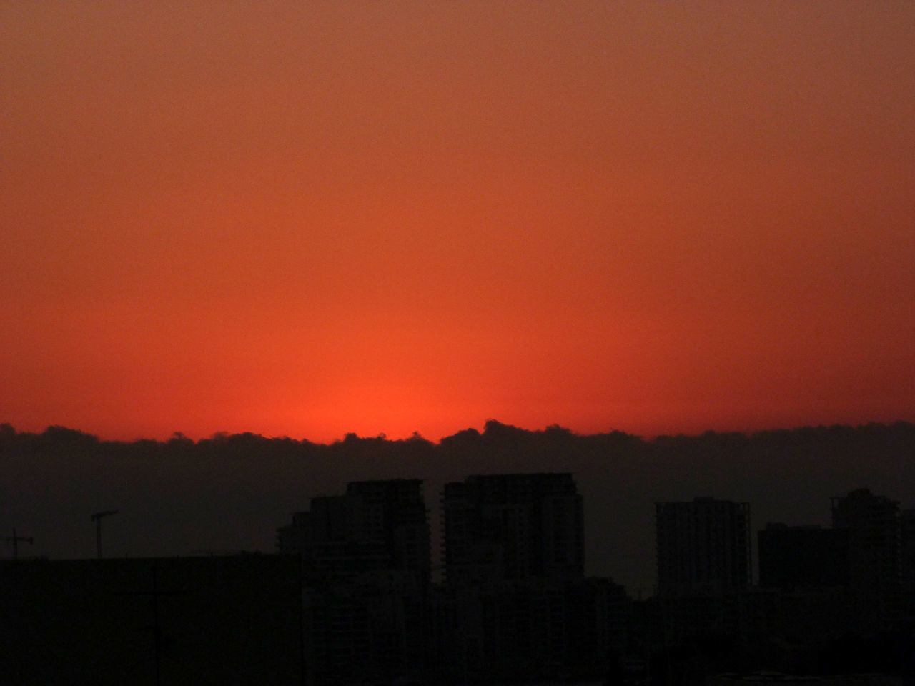 SILHOUETTE BUILDINGS AGAINST DRAMATIC SKY DURING SUNSET