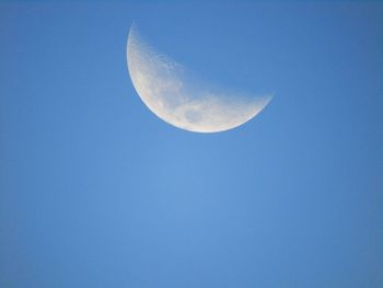 Low angle view of moon against clear blue sky