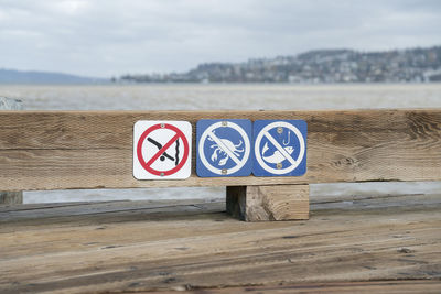 Information sign on beach against sky