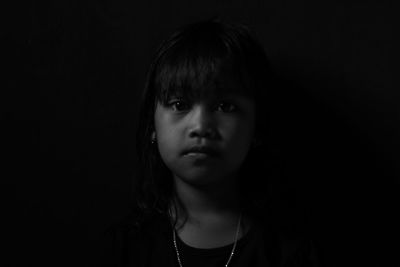 Portrait of girl against black background