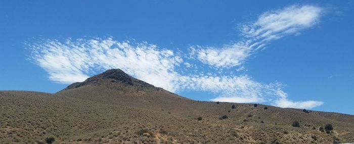 Low angle view of landscape against blue sky