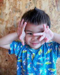 Portrait of cute boy standing against wall