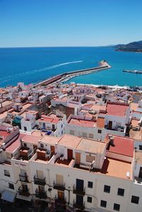 High angle view of townscape by sea against clear sky