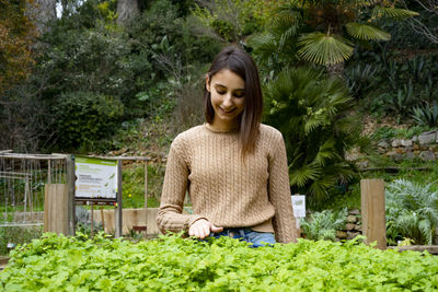 Young gardener touching her plants.