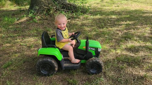 Full length of boy sitting on field