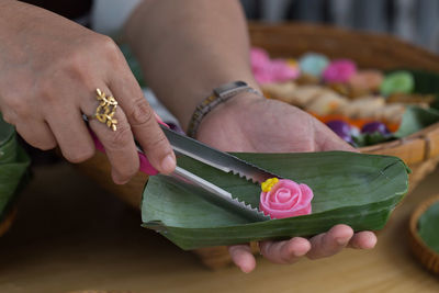 Cropped hands of woman serving food in leaf