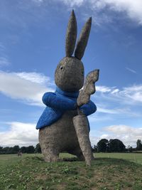 Low angle view of animal representation on field against sky