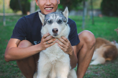 Midsection of man with dog on grass