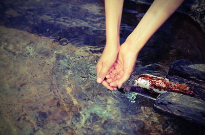 Cropped hands of woman cleaning water