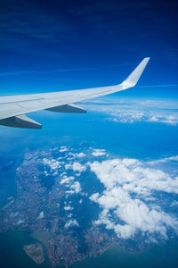 Airplane flying over sea against blue sky