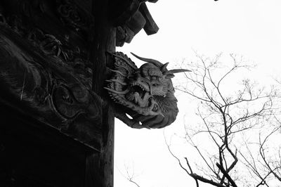 Dragon sculpture on traditional building against clear sky