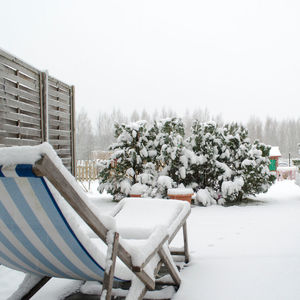 White table and chairs in snow against clear sky