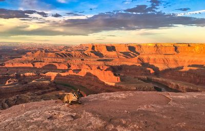 View of rock formations on landscape against cloudy sky