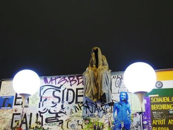 Low angle view of illuminated statue against sky at night