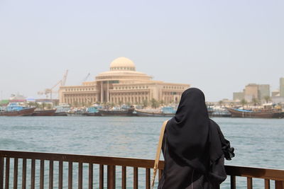 Rear view of woman looking at sea against clear sky