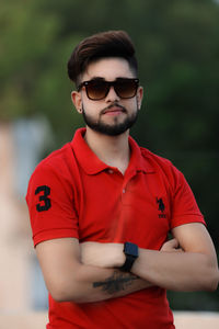 Portrait of young man wearing sunglasses standing outdoors