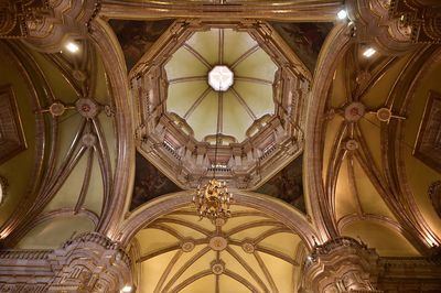 Low angle view of chandelier hanging on ceiling of building
