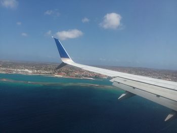 Airplane flying over sea against sky