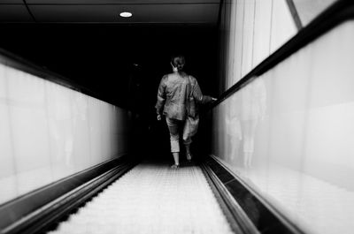 Rear view of man walking in corridor