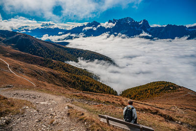 Rear view of man on mountains against sky