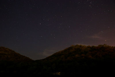 Low angle view of silhouette mountain against sky at night