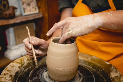 Crafts person working with clay on pottery wheel