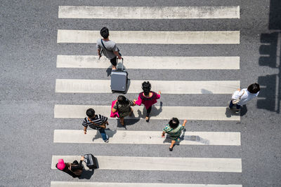 High angle view of people crossing road on zebra crossing in city