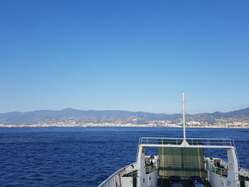 Pier on sea against clear blue sky