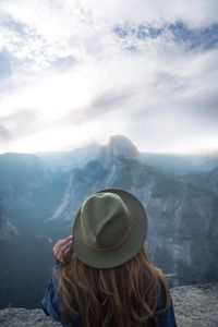 Rear view of woman wearing hat against mountains