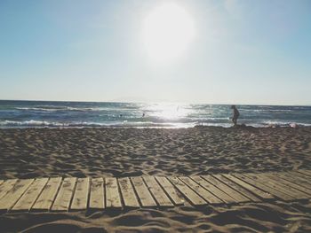 Scenic view of beach against clear sky on sunny day